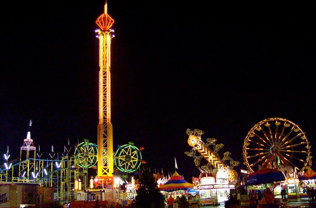 Illuminated midway rides including a tower and Ferris wheel at the Minnesota State Fair in 2006
